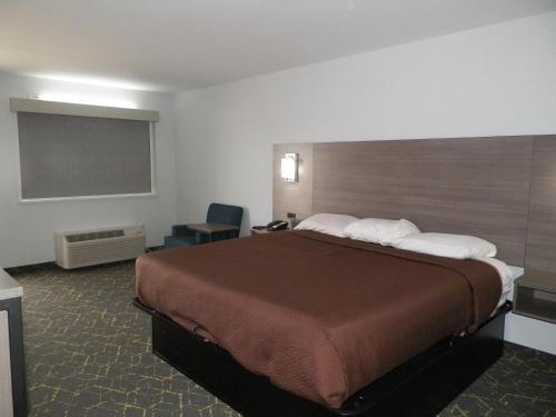 um quarto de hotel com uma cama grande e um quadro negro em Walnut Inn em Roland