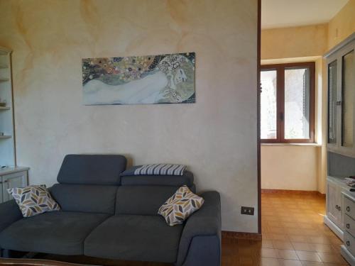 a living room with a couch and a painting on the wall at CASA GIO' GIO' in Selva di Fasano