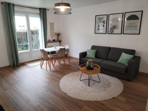 un salon avec un canapé et une table dans l'établissement Cozy studio Pontault-combault proche Disney-Paris, à Pontault-Combault