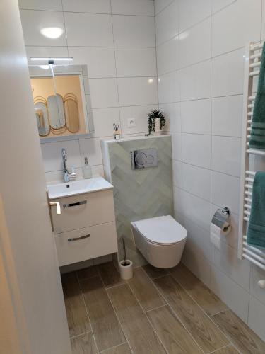 une salle de bain blanche avec des toilettes et un lavabo dans l'établissement Cozy studio Pontault-combault proche Disney-Paris, à Pontault-Combault