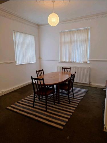 une chambre vide avec une table et des chaises en bois dans l'établissement Favourite Ensuite Room, à Middlesbrough