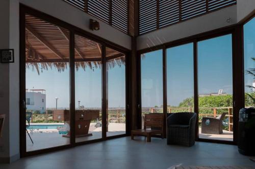uma sala de estar com portas de vidro e vista para uma piscina em ZAFIRO CHINCHA® Casa de Lujo Piscina frente al mar em Casa Blanca