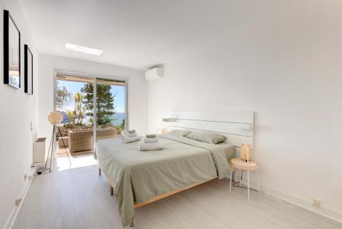 une chambre blanche avec un grand lit et une fenêtre dans l'établissement Giant Terrace on a stunning View, à Villefranche-sur-Mer