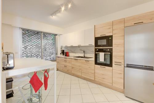 une cuisine avec des appareils électroménagers blancs et des armoires en bois dans l'établissement Giant Terrace on a stunning View, à Villefranche-sur-Mer