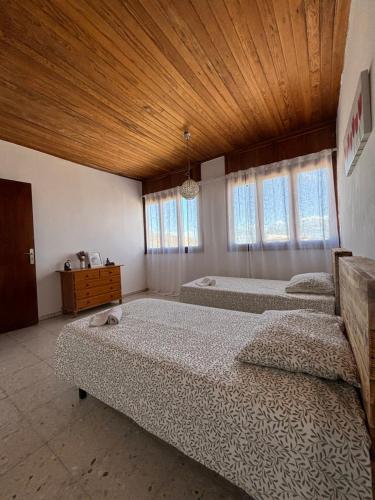 1 dormitorio con 3 camas y techo de madera en Room Yu en Gran Tarajal