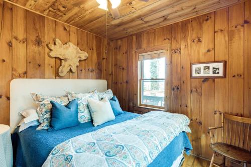 - une chambre avec un lit dans une pièce dotée de murs en bois dans l'établissement Peaceful Hendersonville Cabin - Hot Tub and Fire Pit, à Hendersonville