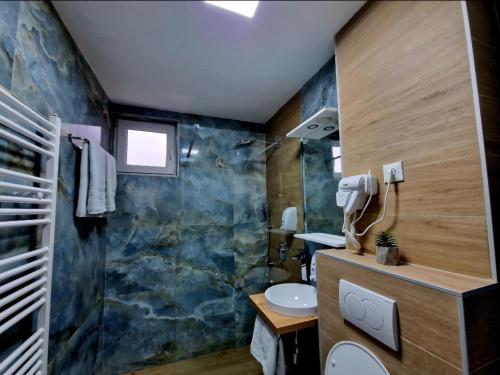een badkamer met een douche, een wastafel en een toilet bij Infinity Apartment & Free Wifi & Free Parking in Sarajevo