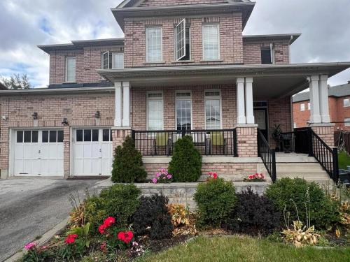 a brick house with white doors and flowers at APARTMENT B 2 BEDROOM in Brampton