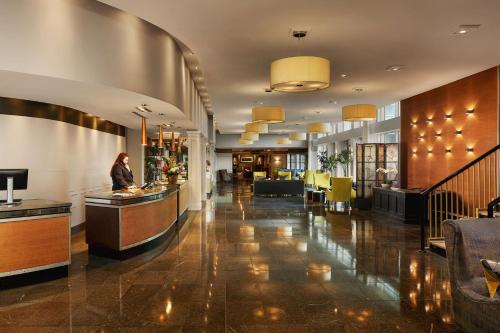 a lobby of a hotel with a woman standing at a counter at Radisson BLU Hotel & Spa, Little Island Cork in Cork