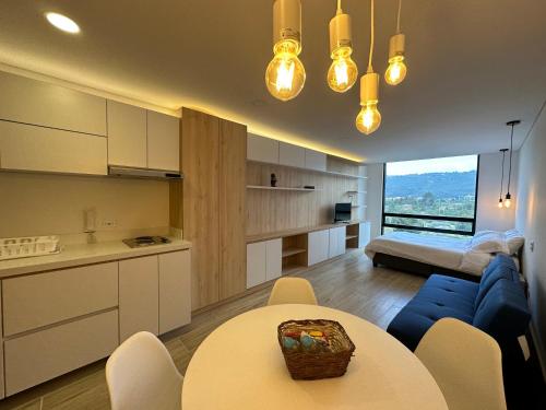 a kitchen and living room with a table and a blue couch at Increible apartamento cerca de Centro Chia y U Sabana in Chía