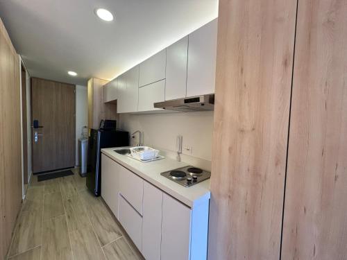 a kitchen with white cabinets and a black refrigerator at Increible apartamento cerca de Centro Chia y U Sabana in Chía