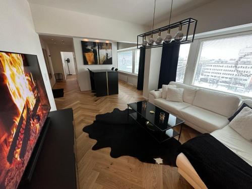un soggiorno con divano bianco e TV di Rewell Suite - Central location and nice view! a Vaasa