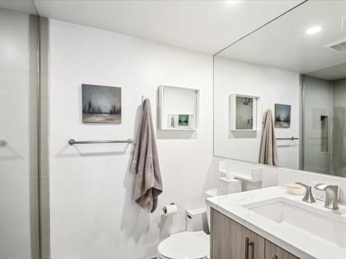 a bathroom with a sink and a toilet and a mirror at Chateau Roaring Fork 24, Remodeled Condo w River Views, Large TVs, Fireplace, Near Gondola! in Aspen