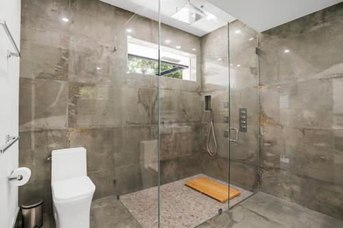 a bathroom with a glass shower with a toilet at Stunning Modern Coastal Villa - The Three Palms in Delray Beach