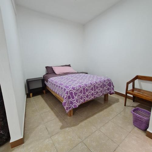 a bedroom with a bed with a purple comforter at Depa Púrpura Caracol in San Antonio de la Cal