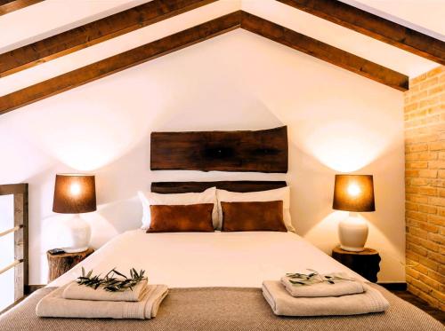 a bedroom with a large white bed with two lamps at Monte do Alento - Castro da Cola in Alcaria