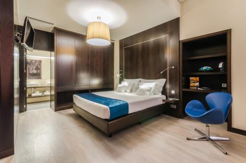 ein Schlafzimmer mit einem Bett und einem blauen Stuhl in der Unterkunft behotelisboa in Lissabon