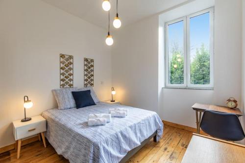 une chambre avec un lit avec deux serviettes dessus dans l'établissement Appart cosy Rétro voyage avec véranda & piano, à Bagnères-de-Bigorre