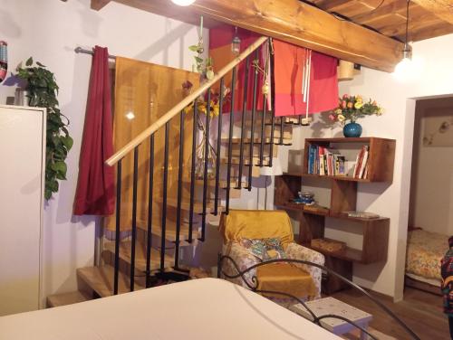 Cette chambre dispose d'un escalier avec une chaise et une étagère. dans l'établissement I Rosai appartamento sulle colline fiorentine, à Bagno a Ripoli