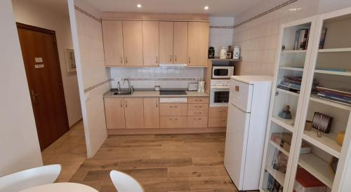 uma cozinha com armários de madeira e um frigorífico branco em Apartament Perebep de Linyola em Linyola