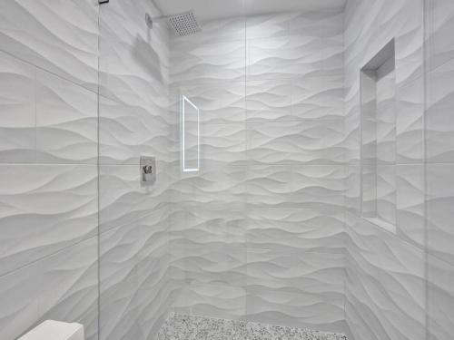 a bathroom with a shower with a glass wall at Cozy Villa Emma in Delray Beach