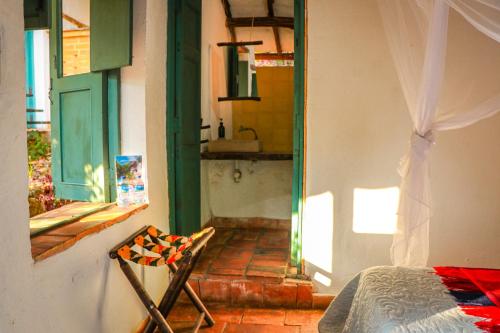 a bedroom with a bed and a doorway to a kitchen at Hotel Spa El Cogollo By MH in Barichara