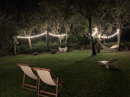two chairs in a yard at night with lights at Cala dei Pirati in Punta Ala