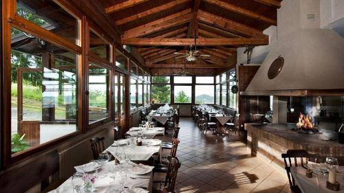 een eetkamer met tafels en stoelen in een restaurant bij S'INCONTRU A CA' DELL' ALPINO in Borra