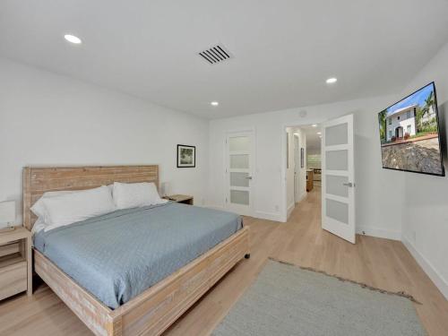 デルレイビーチにあるPeaceful Villa Laurenのベッドルーム1室(ベッド1台、壁にテレビ付)