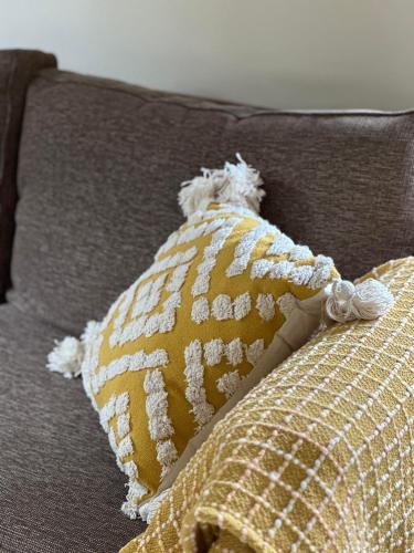 una almohada amarilla con un osito de peluche en un sofá en Blue Bay Studio en Port Macquarie