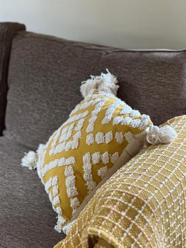 a yellow pillow with a teddy bear on a couch at Blue Bay Studio in Port Macquarie