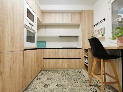 uma cozinha com armários de madeira e uma cadeira preta em LA MACETA em Vilagarcía de Arousa