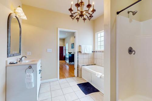 a bathroom with a tub and a sink and a shower at Sandy Feats in Gulf Highlands