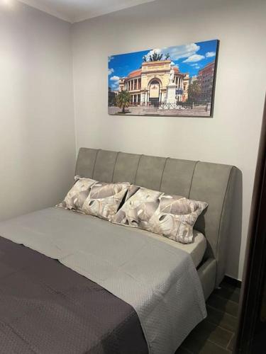 ein Bett in einem Schlafzimmer mit einem Bild an der Wand in der Unterkunft Mrassi in Palermo