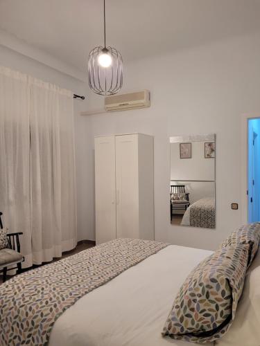 a white bedroom with a bed and a mirror at LIVING CAZORLA II in Cazorla