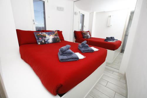 - 2 lits dans une chambre avec draps rouges et serviettes dans l'établissement Gianicolo House, à Rome
