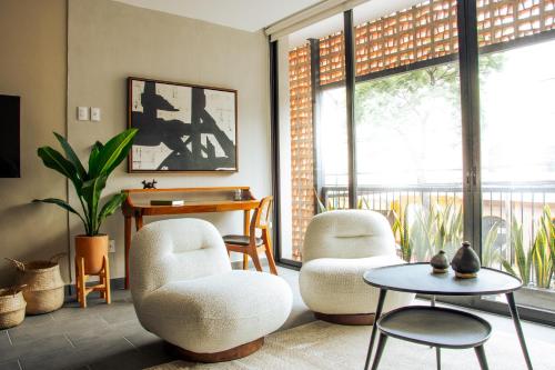 a living room with two chairs and a table at MINERIA By Mr W in Mexico City