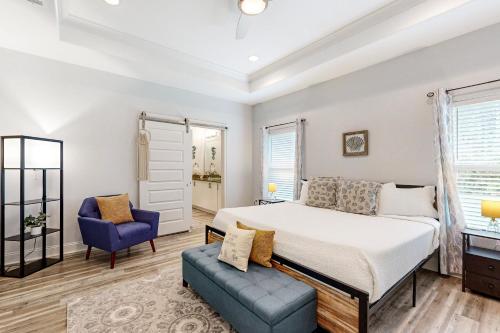 a bedroom with a bed and a blue chair at Emerald Coast Cottage in Navarre