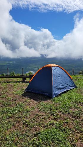 une tente bleue et orange assise dans un champ dans l'établissement Porto das Nuvens, à Viçosa do Ceará