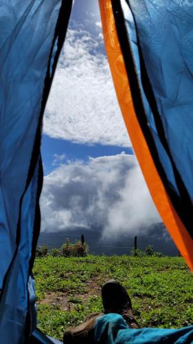 uma pessoa deitada numa tenda a olhar para o céu em Porto das Nuvens em Viçosa do Ceará