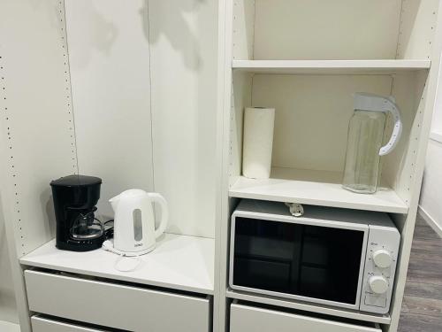 a small kitchen with a microwave and a blender at Private Rooms in center of Billund in Billund