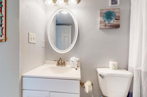 een witte badkamer met een wastafel en een spiegel bij Islander W 703 in Fort Walton Beach