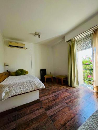 - une chambre avec un lit et une grande fenêtre dans l'établissement Departamento Roque Pérez, à Roque Pérez