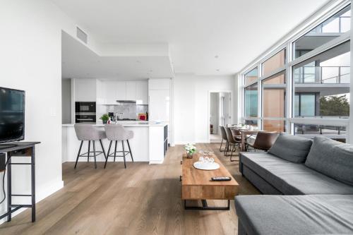 a living room with a couch and a table at Urban Oasis: Stylish Apartment Retreat at UBC in Vancouver