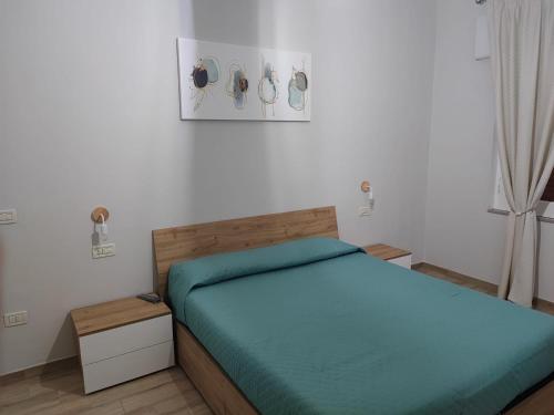Schlafzimmer mit einem Bett mit blauer Tagesdecke in der Unterkunft Casa Seamus Briatico in Briatico