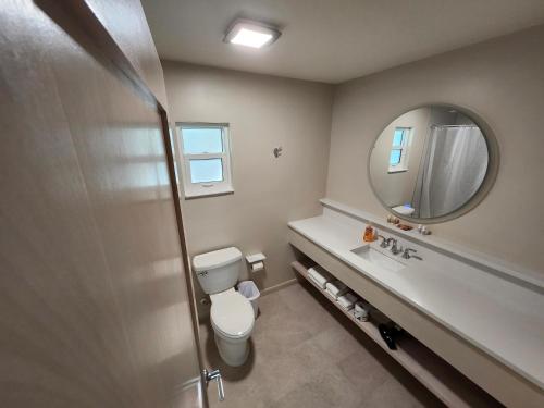 a bathroom with a toilet and a sink and a mirror at Sunshine Island Inn in Sanibel