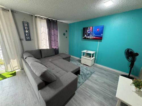 ein Wohnzimmer mit einem Sofa und einem Flachbild-TV in der Unterkunft Panorama Ochi - Sand Castles Resort B20 in Ocho Rios