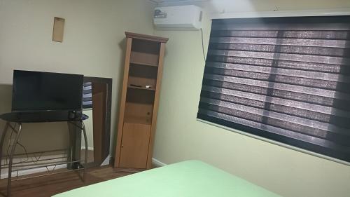 a bedroom with a window with a television in it at Habitación privada bombero garrido in Curicó