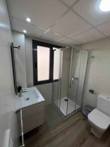 a bathroom with a shower and a toilet and a sink at AB Apartamentos in Melilla