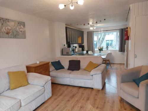 a living room with two white couches and a kitchen at 78 Atlantic Reach in Newquay